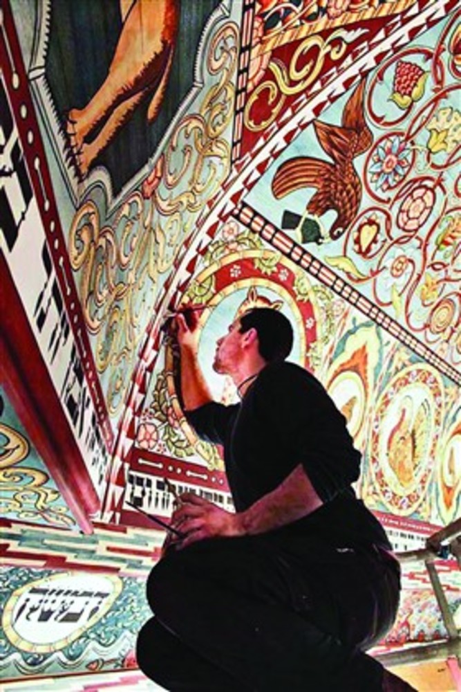 Jason Loik paints the reconstructed ceiling.